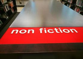 étagères spectacle non-fiction rouge signe dans une bibliothèque. photo