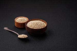 sain brut quinoa dans une bol sur une foncé béton Contexte photo