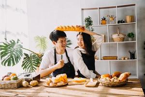 image de nouveau marié couple cuisine à maison. Asie Jeune couple cuisine ensemble avec pain et fruit dans confortable cuisine dans Accueil photo
