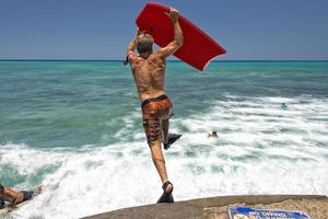 homme sauter de jetée avec corps le surf photo