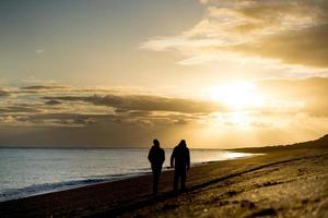 silhouette d'homme sur la plage au lever du soleil photo