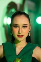 une magnifique asiatique femme dans une vert robe a une très exotique visage avec oreille et corps bijoux tandis que photo