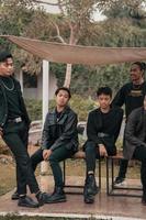 une groupe de asiatique adolescents dans noir vêtements stylisé comme vilain les enfants tandis que rassemblement à une café photo