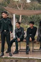 une groupe de asiatique adolescents dans noir vêtements stylisé comme vilain les enfants tandis que rassemblement à une café photo