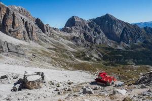 touristique avec randonnée sacs à dos dans Montagne une randonnée sur été journée. homme voyageur randonnée dans magnifique Montagne paysage. grimpeur et alpin cabane silvio agostini dans dolomites Alpes, Italie. photo