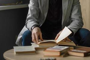 une homme dans le Bureau à le table lit livres. monde livre journée photo