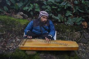 une homme en jouant kecapi traditionnel sundanais la musique dans le ciwidey, Bandung, ouest Java, Indonésie. photo