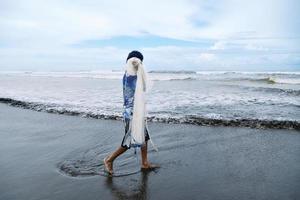 pêcheur des promenades avec le sien net sur le mer rive. photo