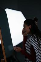 jeune femme se maquille le visage devant le miroir photo