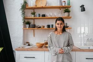 jeune femme debout près du bureau dans la cuisine photo