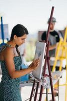 jeune femme artiste peint avec une spatule sur la toile photo