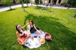 deux femmes en train de pique-niquer ensemble, assises sur le plaid photo