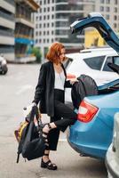 une femme met des choses dans la voiture photo