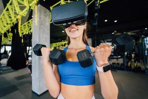 femme portant des lunettes de réalité virtuelle faisant de l'exercice avec des haltères photo