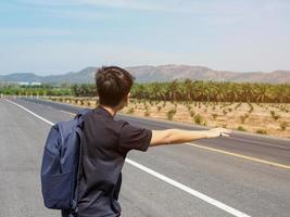 une homme permanent auto stoppeuse sur le route dans rural zones photo