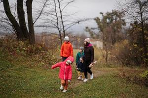 mère avec sa quatre des gamins dans l'automne forêt. photo