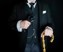 portrait de gentilhomme dans noir costume en portant cuir gants et parapluie. Britanique homme d'affaire ou classique majordome photo