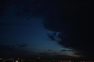 foncé bleu nuage avec blanc lumière le coucher du soleil ciel Contexte et ville lumière minuit soir temps photo