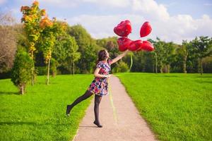 Jeune femme avec rouge cœur des ballons photo