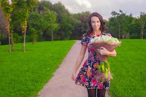 Jeune femme en portant une bouquet photo