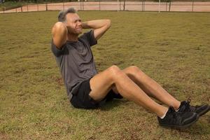 mature homme à l'extérieur sur le herbe Faire asseoir UPS photo