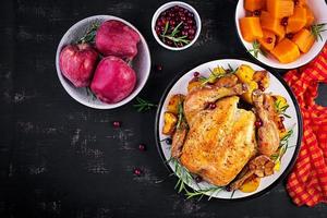 rôti dinde garni avec canneberges sur une rustique style table décoré l'automne feuille. action de grâces journée. cuit poulet. Haut vue photo