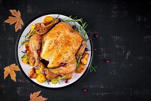 rôti dinde garni avec canneberges sur une rustique style table décoré l'automne feuille. action de grâces journée. cuit poulet. Haut vue photo