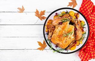 rôti dinde garni avec canneberges sur une rustique style table décoré l'automne feuille. action de grâces journée. cuit poulet. Haut vue photo