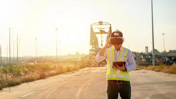 asiatique ingénieur en utilisant virtuel réalité casque et tablette pour inspecter et travail à construction site photo