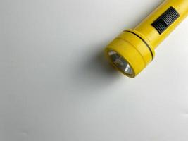 Jaune lampe de poche sur blanc Contexte. copie espace. lampe de poche pour coupure électrique et urgence. choisi concentrer photo