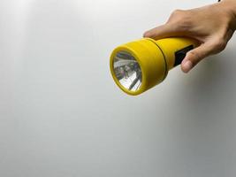 Jaune lampe de poche sur blanc Contexte. copie espace. lampe de poche pour coupure électrique et urgence. choisi concentrer photo