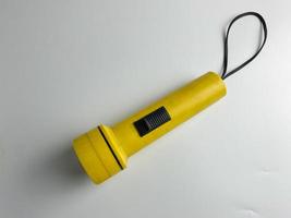 Jaune lampe de poche sur blanc Contexte. copie espace. lampe de poche pour coupure électrique et urgence. choisi concentrer photo