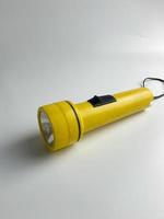 Jaune lampe de poche sur blanc Contexte. copie espace. lampe de poche pour coupure électrique et urgence. choisi concentrer photo