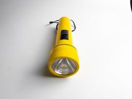 Jaune lampe de poche sur blanc Contexte. copie espace. lampe de poche pour coupure électrique et urgence. choisi concentrer photo