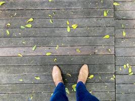 aux femmes jambes dans une Facile marron chaussures. Haut vue de femme jambe portant des chaussures et maigre bleu jeans. Facile et rue mode. photo