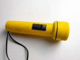 Jaune lampe de poche sur blanc Contexte. copie espace. lampe de poche pour coupure électrique et urgence. choisi concentrer photo