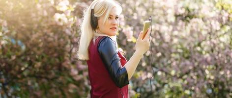 magnifique Jeune femme dans une écouteurs écoute la musique dans le parc. instagram photo