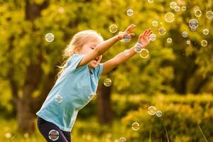 marrant peu fille contagieux savon bulles dans le été sur la nature. Contexte tonifiant instagram filtre. content enfance concept photo