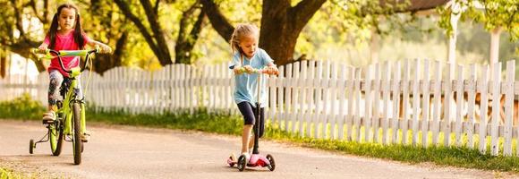 une groupe de content les enfants sans encombre équitation leur vélo sur le rue photo