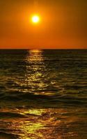 coucher de soleil doré coloré grande vague et plage puerto escondido mexique. photo