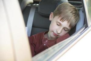le enfant dort dans le auto. le peu garçon a été fatigué et est tombée endormi dans le auto. photo