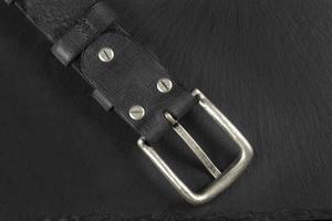 ceinture en cuir noir sur fond sombre. produits en cuir. photo