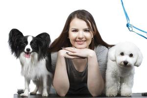 content fille en portant mignonne bichon et papillon chiens. photo