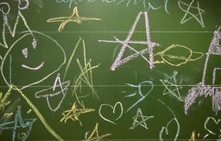 dessins de les enfants avec craie sur une école vert planche. photo