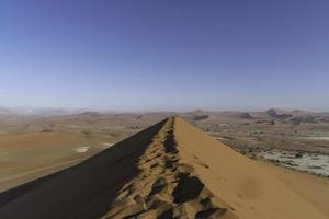 une sentier sur Haut de une dune dans le namibien désert. photo