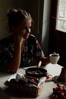 fille ayant petit déjeuner dans le cuisine de bonne heure dans le Matin photo