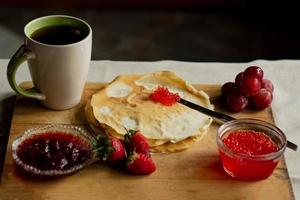 crêpe avec rouge caviar pour petit-déjeuner, une tasse de thé photo