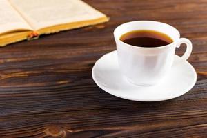 vieux livre et une tasse de café sur un fond en bois, image tonique photo