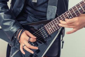 proche en haut de homme en jouant électrique guitare. photo