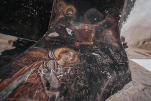 une la grotte église dans la cappadoce avec les inscriptions sur le des murs, fresques de le début de christianisme. photo